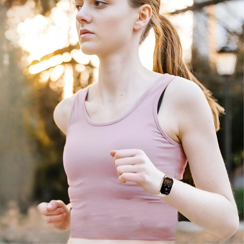 Montre Connectée Femme Rose à Grand Écran Doré portée par une femme sportive qui court