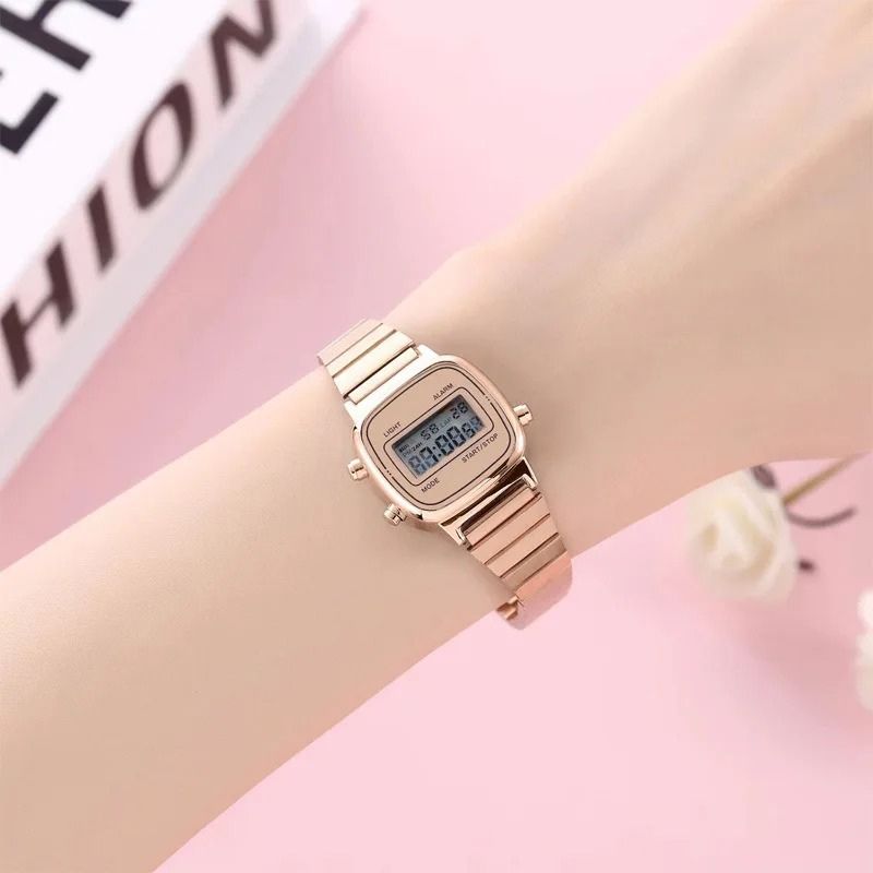 Montre Digitale Femme au Design Carré Rétro couleur or rose, portée au poignet d'une femme blanche