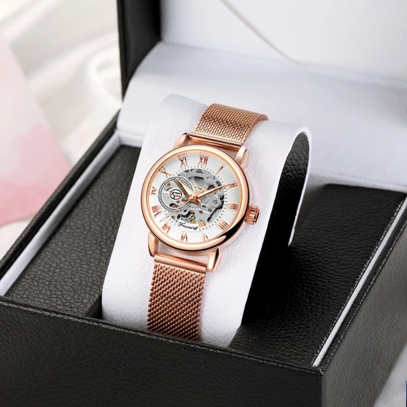 Montre Automatique Femme Bracelet Acier Maille & Cadran Ajouré en rose sur son support pour montre