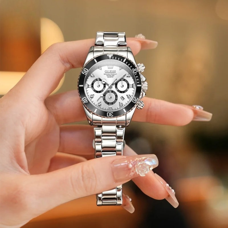 Montre Chronographe Femme Argentée Lunette Noire 35 mm tenue dans une main de femme