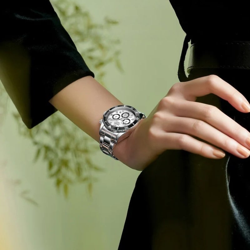 Montre Chronographe Femme Argentée Lunette Noire 35 mm portée au poignet d'une femme qui se tient la hanche