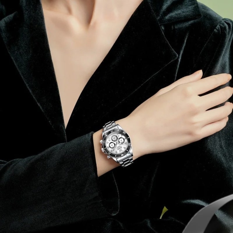 Montre Chronographe Femme Argentée Lunette Noire 35 mm portée au poignet d'une femme habillée en noir