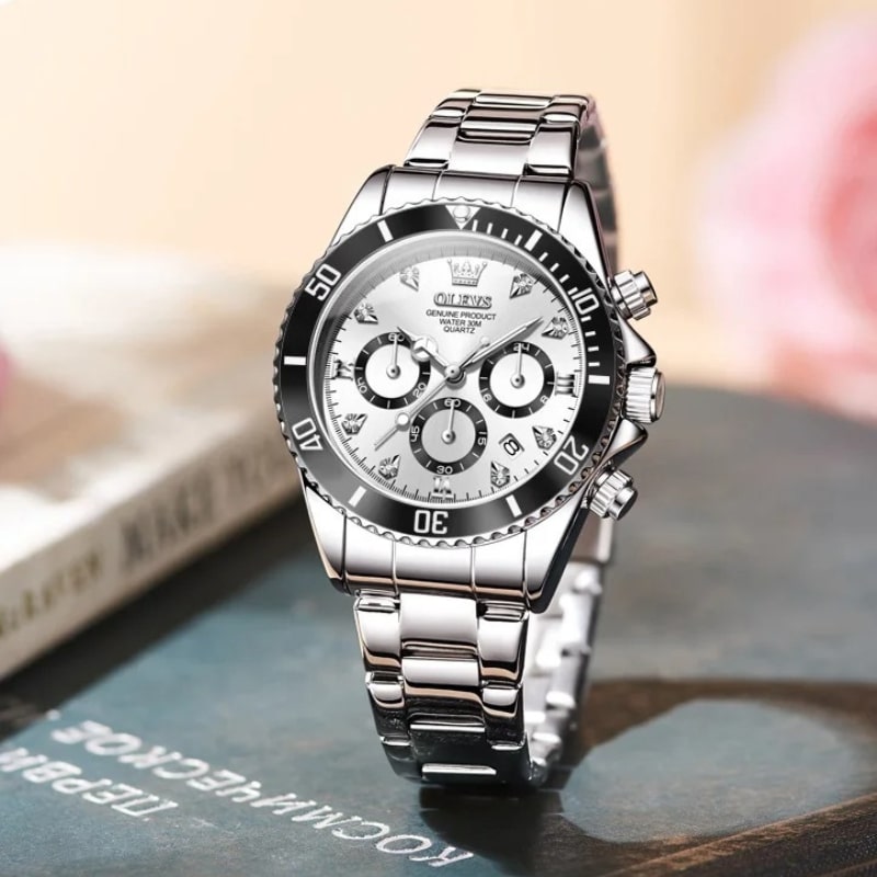 Montre Chronographe Femme Argentée Lunette Noire 35 mm posée sur un live