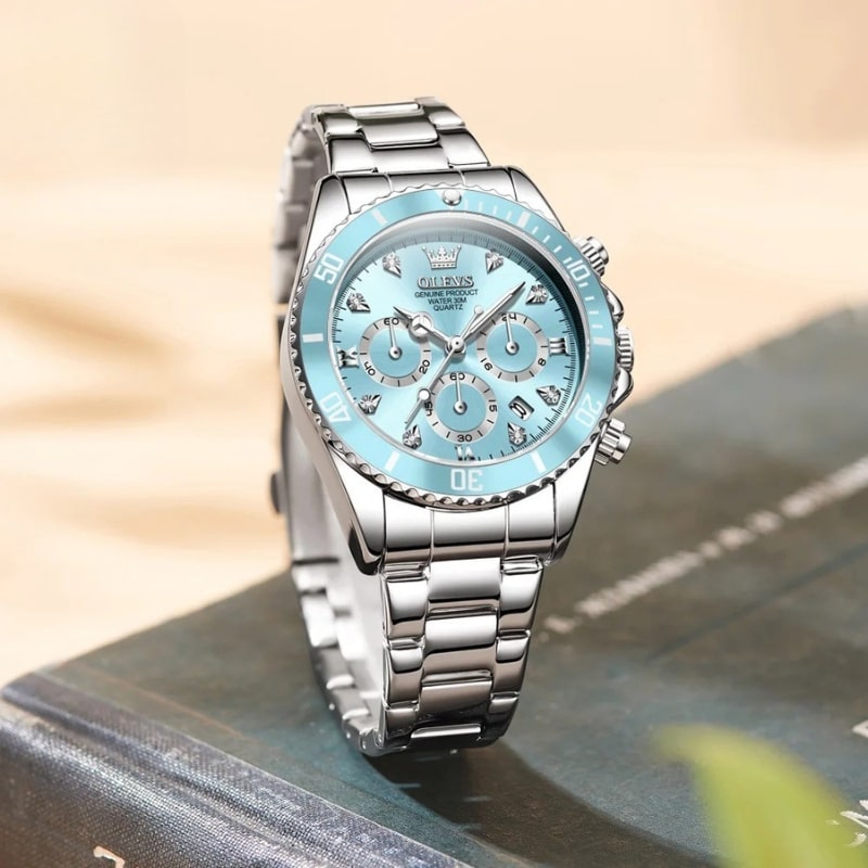 Montre chronographe femme cadran bleu glacier et acier miroir posée sur un live