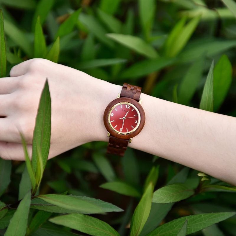 Montre Bois Femme au Cadran Épuré et Coloris Naturels rouge au poignet d'une femme blanche