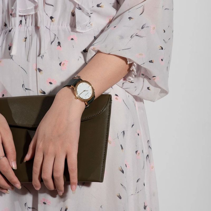 Montre Bois Femme Colorée au Cadran Minimaliste Doré couleur verte portée au poignet d'une femme blanche