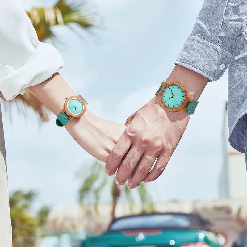 Montre Bois Femme au Cadran Turquoise Naturel portée aux poignets d'un couple qui se tient la main Image