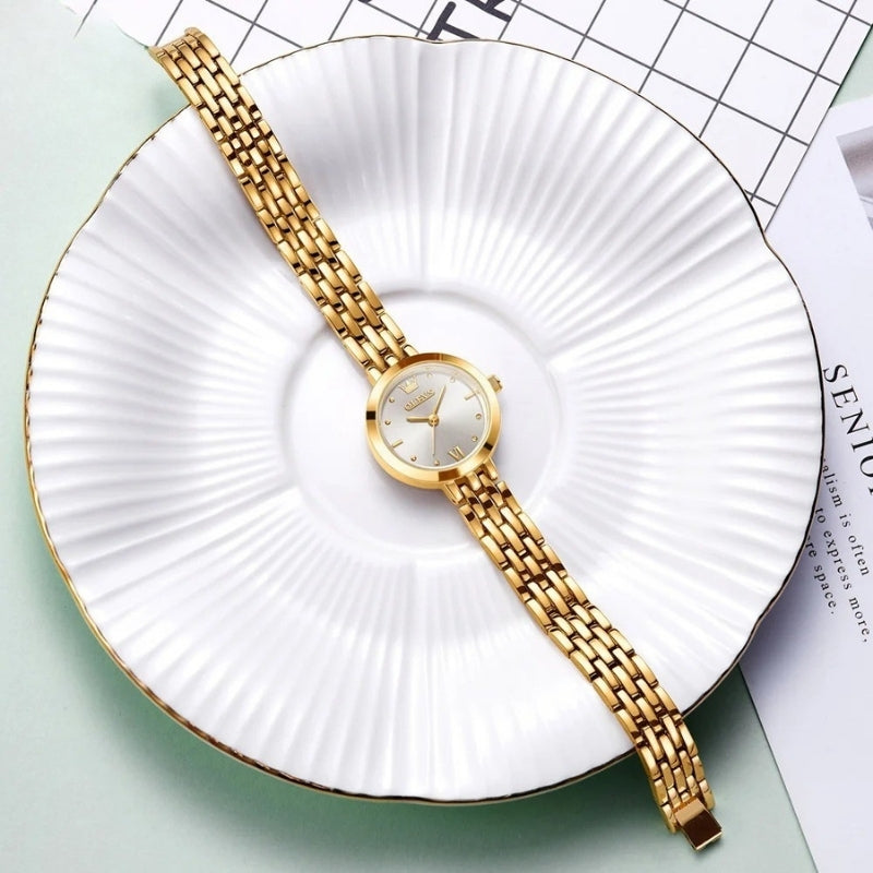 Montre Vintage de luxe pour Femme dorée disposée sur une assiette blanche, design fin et raffiné.