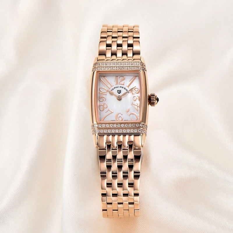 Montre Vintage pour Femme de forme rectangulaire or rose posée sur tissu clair, cadran nacré élégant et finition brillante.
