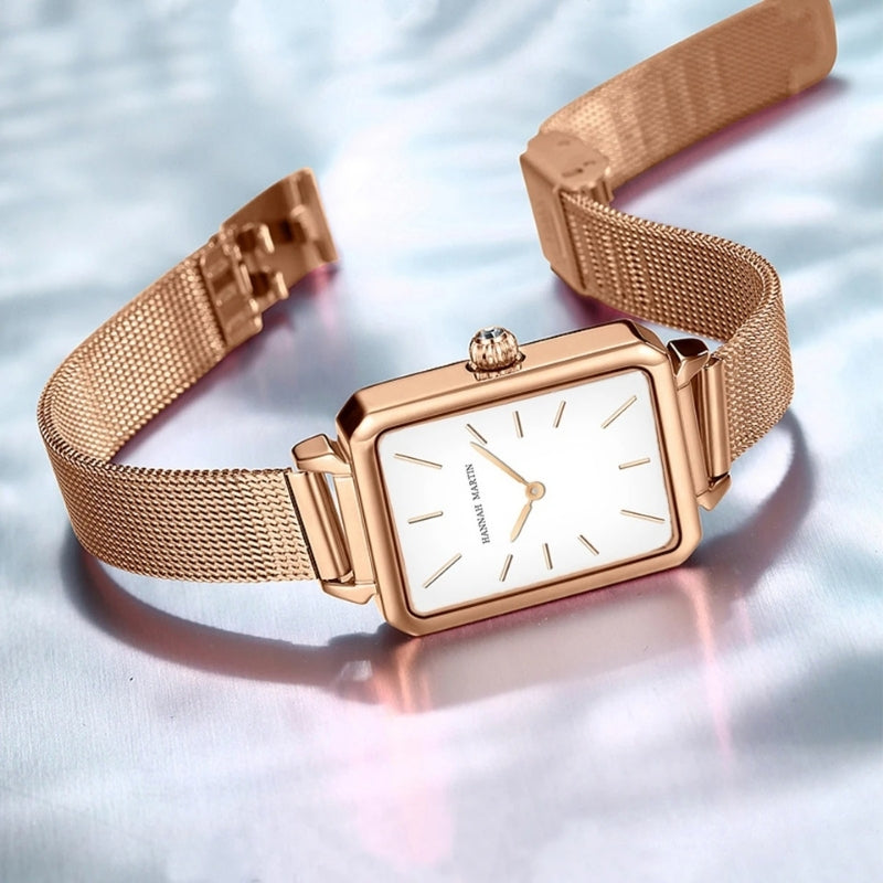 Montre Vintage pour Femme de forme rectangulaire dorée à maille fine présentée dans son écrin, cadran noir et boîtier élégant.