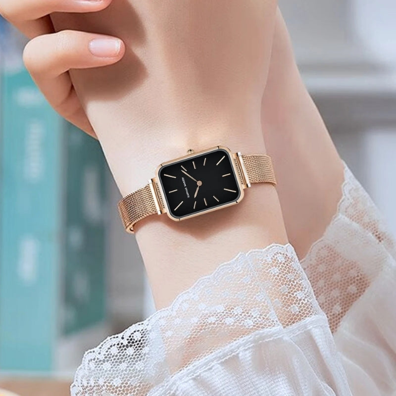 Montre Vintage pour Femme de forme rectangulaire argentée à maille fine, cadran noir moderne et lignes sobres.
