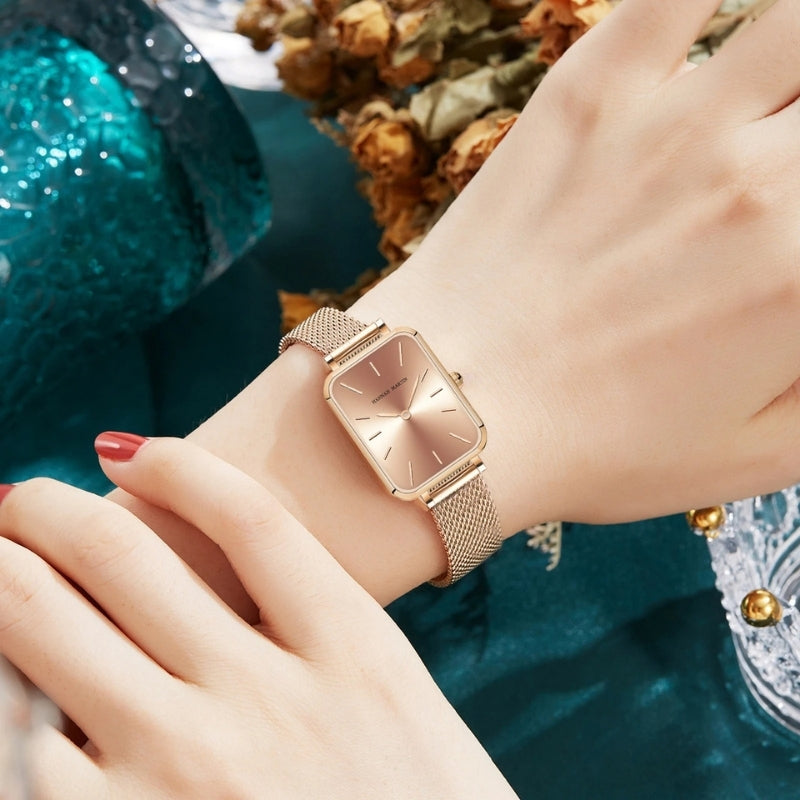Montre Vintage pour Femme de forme rectangulaire dorée à maille fine portée au poignet, cadran or doux et look féminin raffiné.