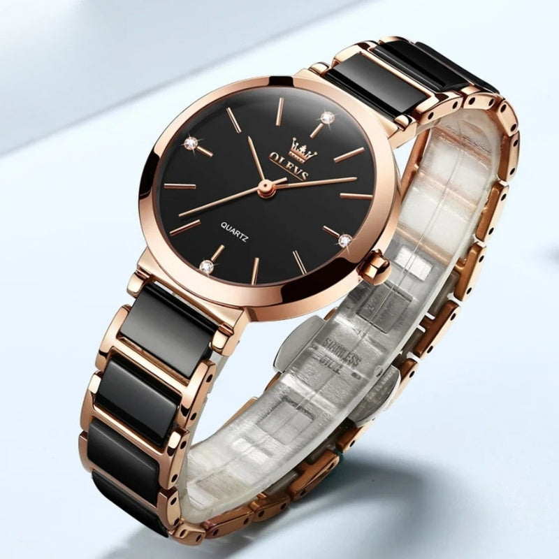 Montre Vintage pour Femme de forme ronde or rose et noire, cadran sombre contrasté et finition brillante. Image