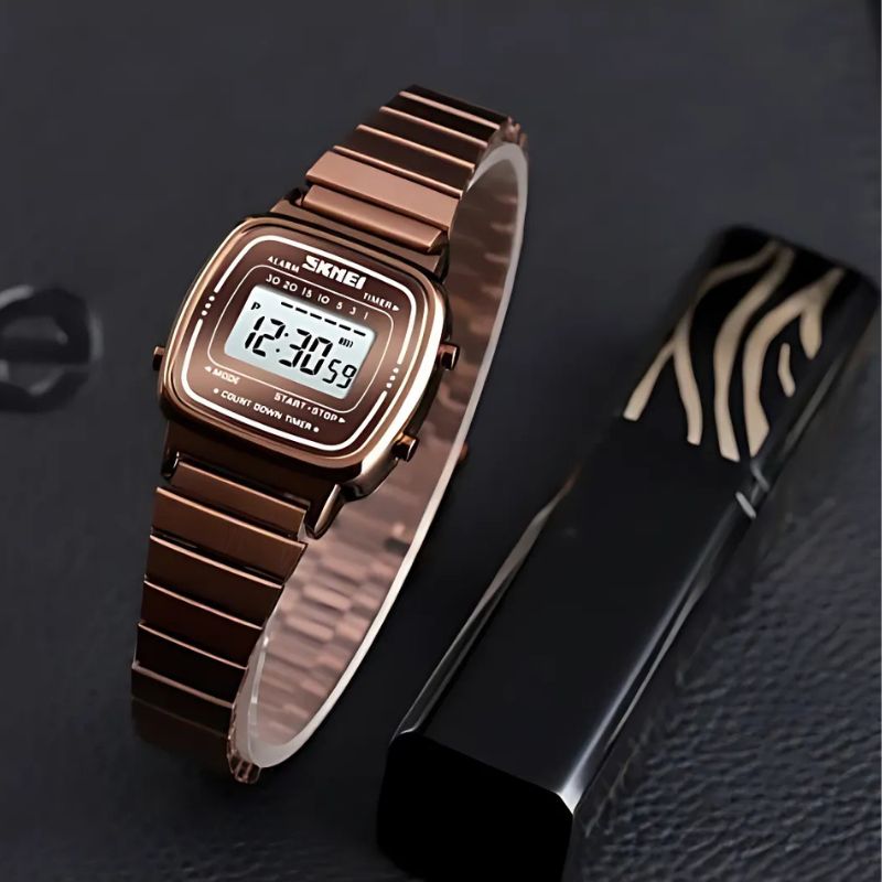 Montre Digitale Femme au Cadran Carré Métallisé couleur or rose posée sur un fond décoratif Image