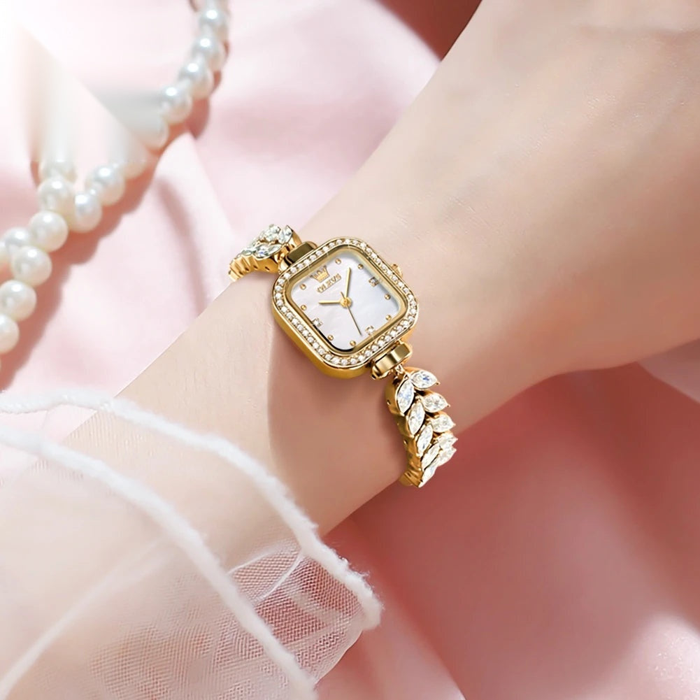 Montre vintage femme dorée portée au poignet, cadran nacre Image