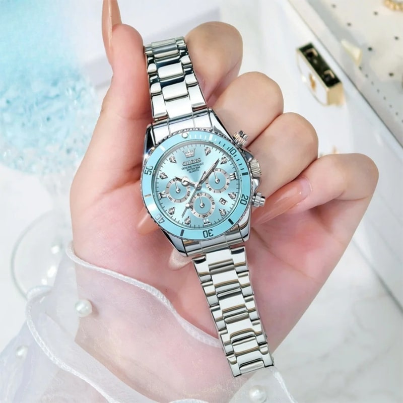 Montre chronographe femme cadran bleu glacier et acier miroir portée dans la main d'une femme blanche